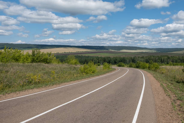 istock An asphalt road with white markings stretching into the distance. 1044188968