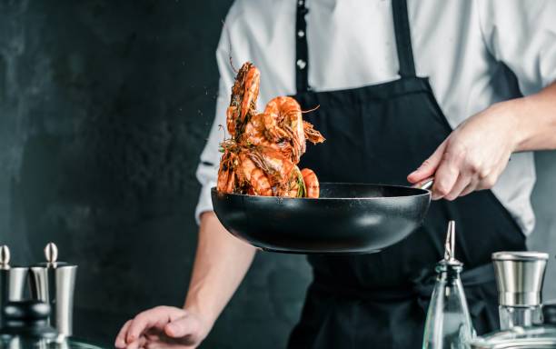 어두운 배경에 타이거 새우로 요리 하는 요리사 - shrimp pan cooking prepared shrimp 뉴스 사진 이미지