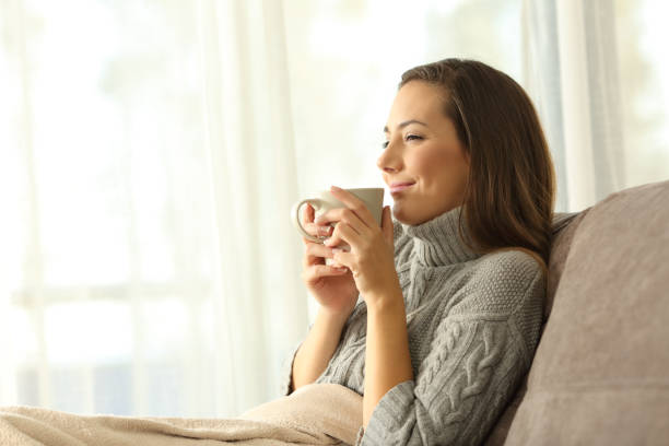 femme en dégustant une tasse de café en hiver à la maison - coffee table living room indoors comfortable photos et images de collection