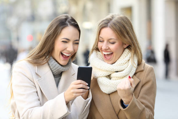 istock Excited friends reading phone content in winter 1044202610