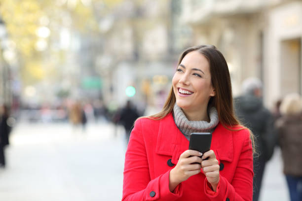 istock Woman looking at side holding a phone in winter 1044205042