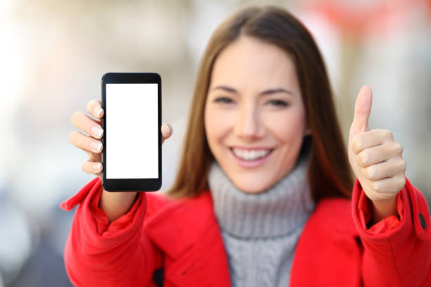 istock Woman showing a blank smart phone screen in winter 1044205288