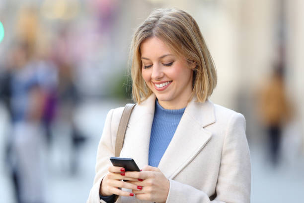 istock Elegant woman using a smart phone on the street 1044205590