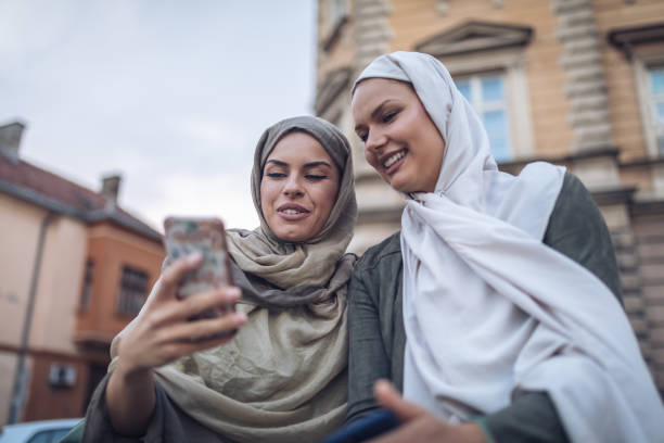 istock Gorgeous Arabic students looking at social media on a mobile phone 1044207540