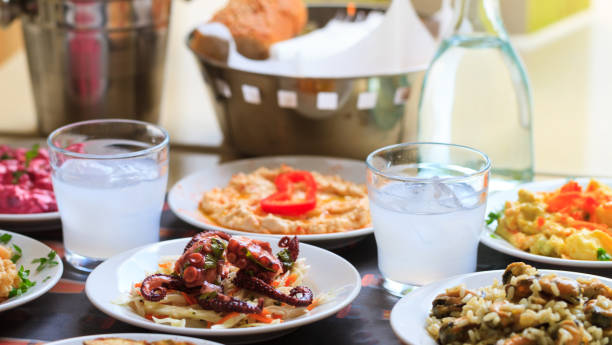 Ouzo in short glasses with ice. Appetizers of seafood in plates. Blur backdrop, close up, details Cool ouzo in short glasses with meze, appetizers of seafood. Blurred background, close up, details meze stock pictures, royalty-free photos & images