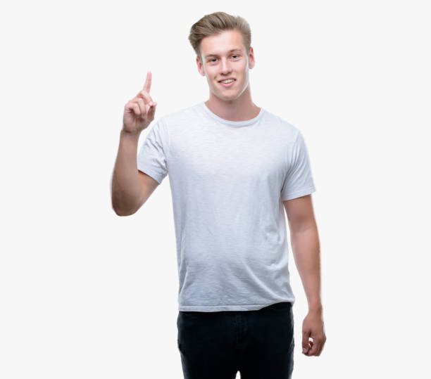 istock Young handsome blond man surprised with an idea or question pointing finger with happy face, number one 1044211522