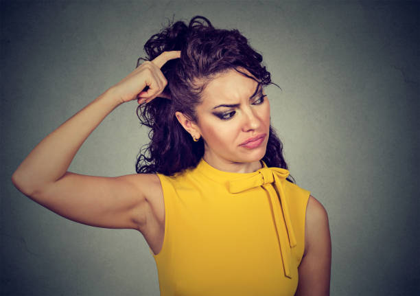 istock Forgetful young woman scratching head 1044217692