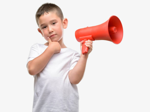 istock Dark haired little child holding megaphone serious face thinking about question, very confused idea 1044218290