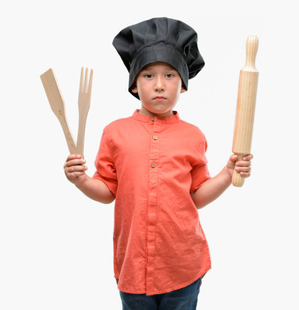 istock Dark haired little child wearing chef uniform with a confident expression on smart face thinking serious 1044222738