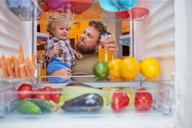 istock Father and son standing in front of opened fridge. 1044224196