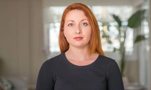 Photo of Redhead woman at home with a confident expression on smart face thinking serious