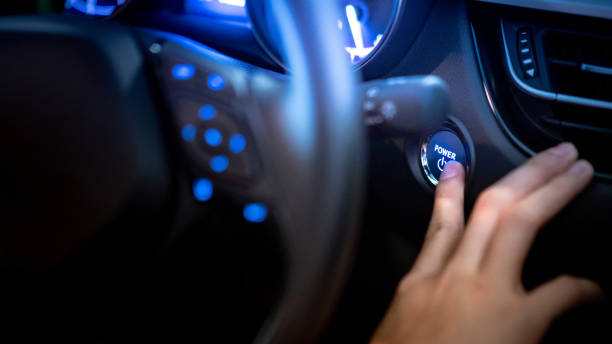 conducente maschio che spinge il pulsante di arresto dell'auto o il pulsante di accensione della potenza dal volante nell'auto moderna con cruscotto a luce blu sulla console. tecnologia di trasporto automobilistico per l'industria automobilistica - beginnings car engine ignition foto e immagini stock