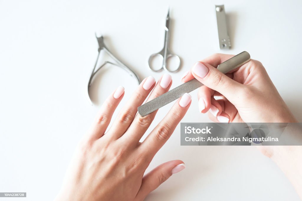 Woman making manicure with nail care tools background. French manicure. Nail salon. Nail File Stock Photo