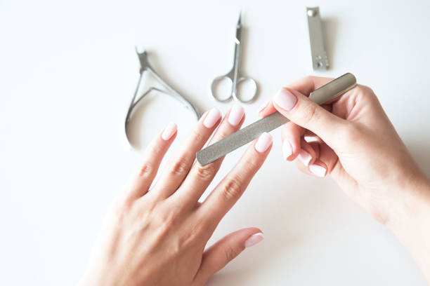 Woman making manicure with nail care tools background. French manicure. stock photo