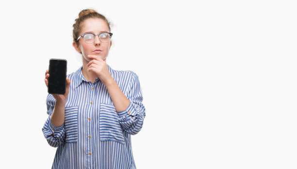 istock Young blonde woman using smartphone serious face thinking about question, very confused idea 1044242822