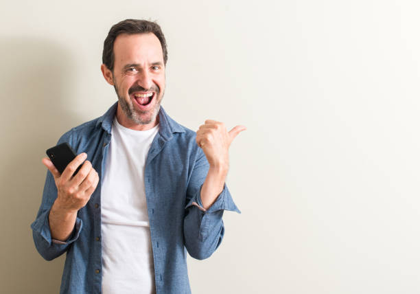 istock Senior man using smartphone pointing with hand and finger up with happy face smiling 1044245576