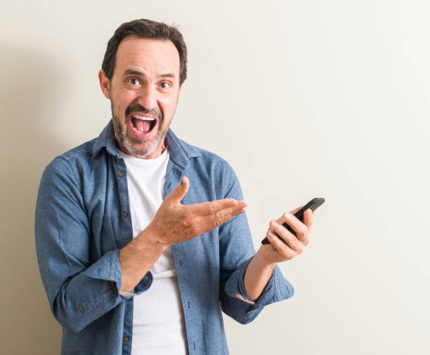 istock Senior man using smartphone very happy pointing with hand and finger 1044247094