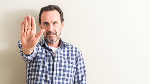 istock Senior man with open hand doing stop sign with serious and confident expression, defense gesture 1044247572
