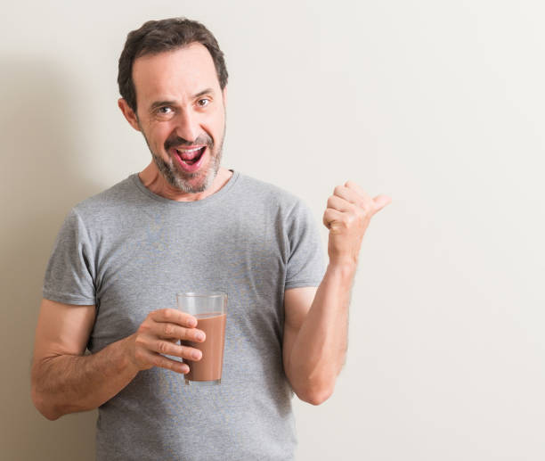 istock Senior man drinking chocolate milk shake pointing with hand and finger up with happy face smiling 1044252968