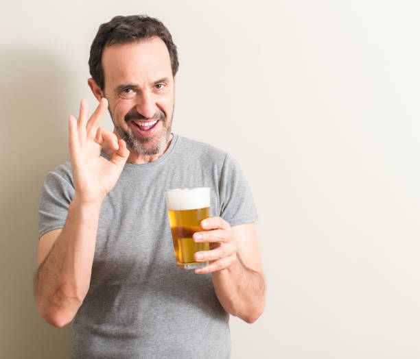 istock Senior man drinking beer doing ok sign with fingers, excellent symbol 1044253318