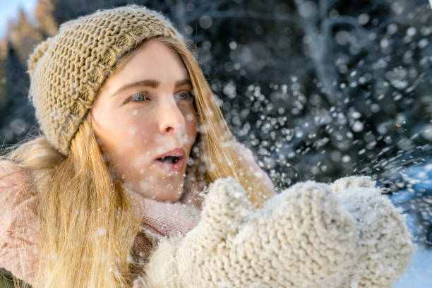istock Woman blowing snow into air 1044253828