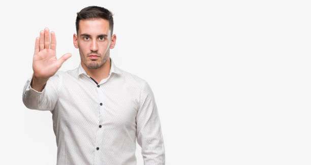 istock Handsome young business man with open hand doing stop sign with serious and confident expression, defense gesture 1044257262