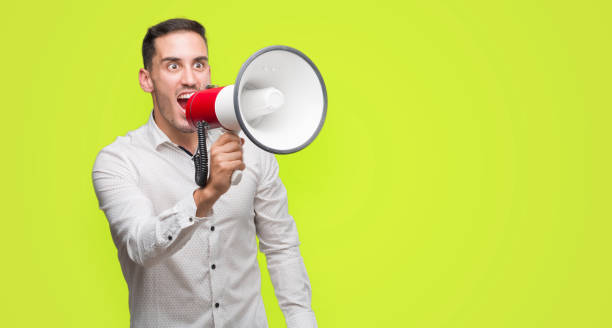 istock Handsome young man holding microphone annoyed and frustrated shouting with anger, crazy and yelling with raised hand, anger concept 1044257278