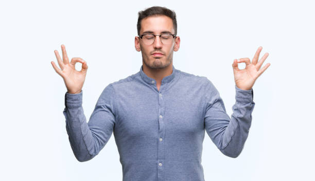istock Handsome young elegant man wearing glasses relax and smiling with eyes closed doing meditation gesture with fingers. Yoga concept. 1044258026