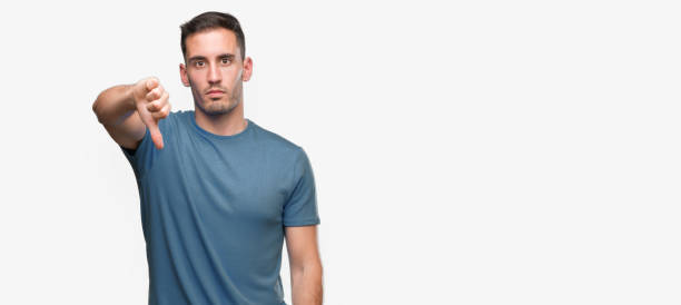 istock Handsome young casual man looking unhappy and angry showing rejection and negative with thumbs down gesture. Bad expression. 1044258756