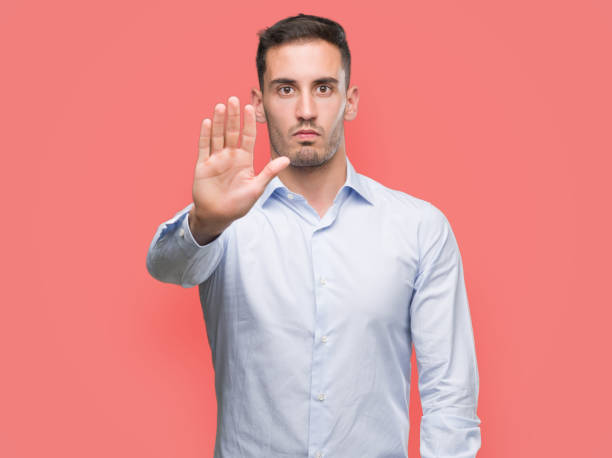 istock Handsome young businessman doing stop sing with palm of the hand. Warning expression with negative and serious gesture on the face. 1044259462