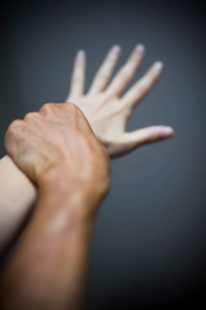 Studio shot of woman holding male hand