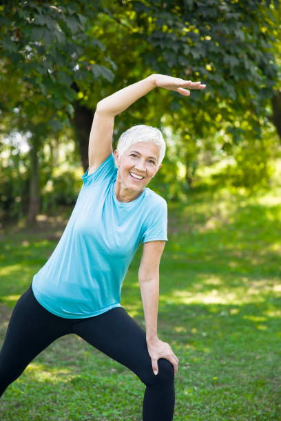 istock Senior woman doing streching exercise in the park 1044266526