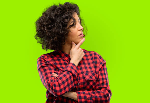 Beautiful arab woman thinking and looking up expressing doubt and wonder