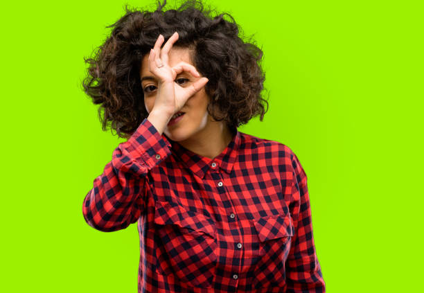 istock Beautiful arab woman looking at camera through fingers in ok gesture. Imitating binoculars, beautiful eyes and smile 1044268064