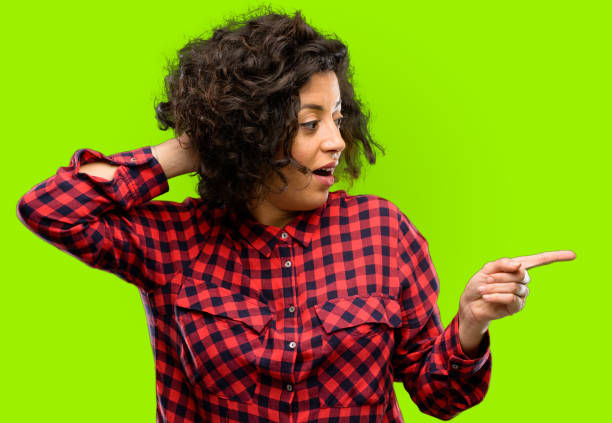 istock Beautiful arab woman pointing away side with finger 1044268368