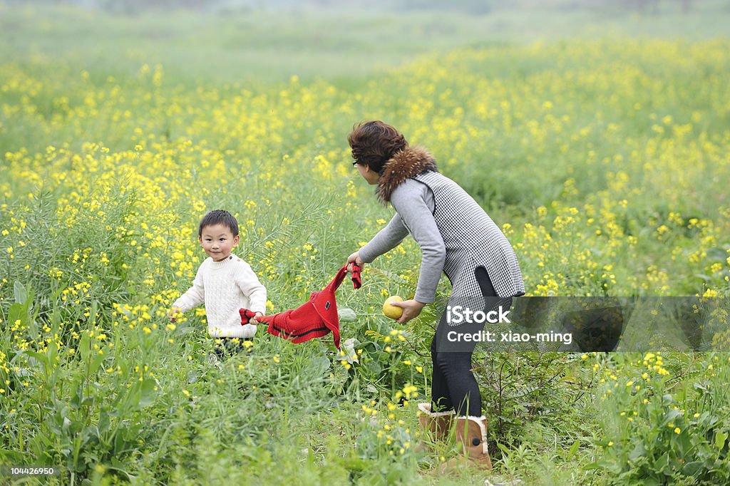 Mãe e filho ao ar livre com flores - Foto de stock de Abraçar royalty-free