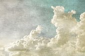 Blue sky with white clouds in retro grunge style. Nature background.