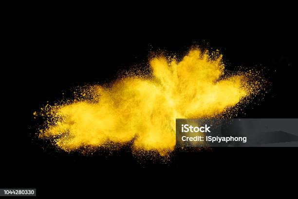 Closeup Of Yellow Dust Particle Splash Isolated On Black Background Stock Photo - Download Image Now