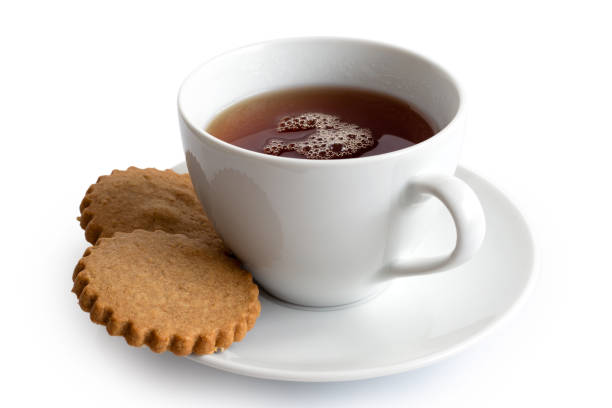 istock A cup of black tea with two gingerbread biscuits isolated on white. White ceramic cup and saucer. 1044280670