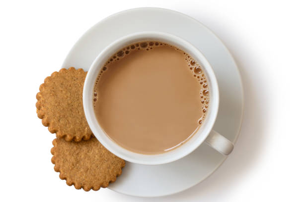 istock A cup of tea with milk and two gingerbread biscuits isolated on white from above. White ceramic cup and saucer. 1044280828