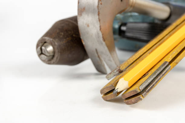Measure and pencil on a white workshop table. Tools in a carpentry workshop. White background.