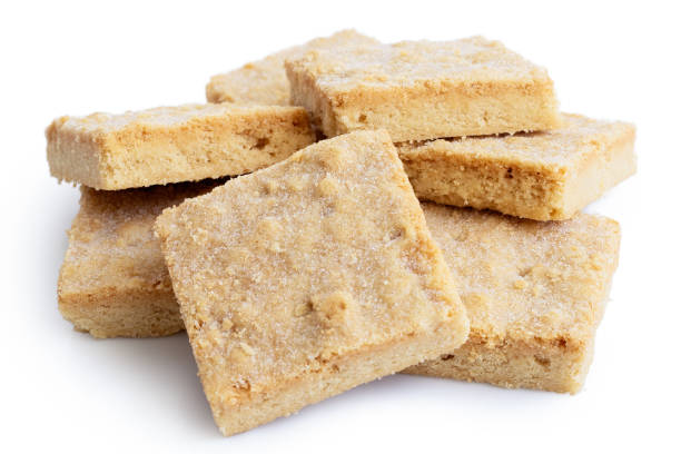 istock Pile of classic homemade square shortbread biscuits isolated on white. 1044283484