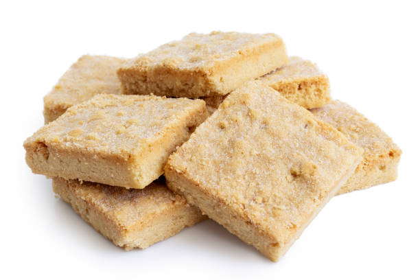 istock Pile of classic homemade square shortbread biscuits isolated on white. 1044283568