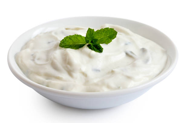 istock Tzatziki in white ceramic bowl isolated on white. Mint leaf garnish. 1044284836