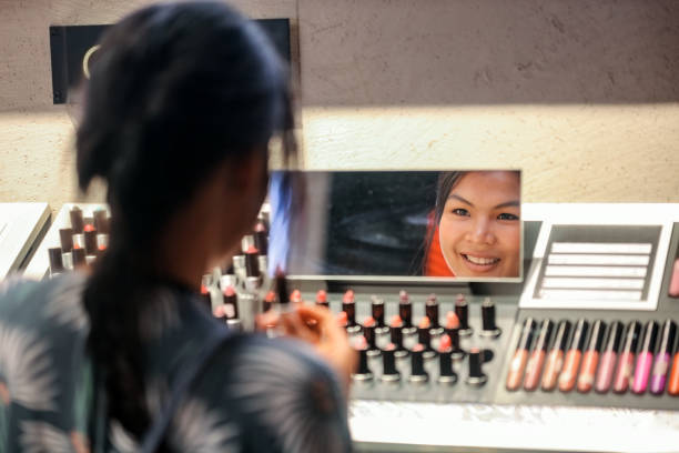 Asian woman choosing lipstick in department store