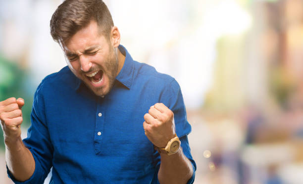 istock Young handsome man over isolated background very happy and excited doing winner gesture with arms raised, smiling and screaming for success. Celebration concept. 1044298414