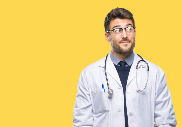 istock Young handsome doctor man over isolated background smiling looking side and staring away thinking. 1044298754