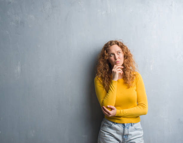 istock Young redhead woman over grey grunge wall serious face thinking about question, very confused idea 1044303020