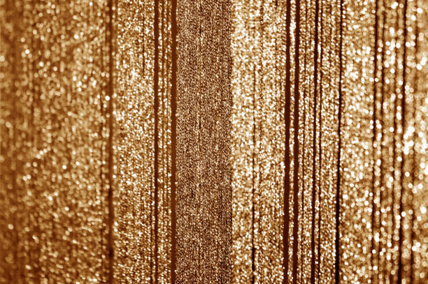 istock Golden curtains made of shiny threads. 1044303556