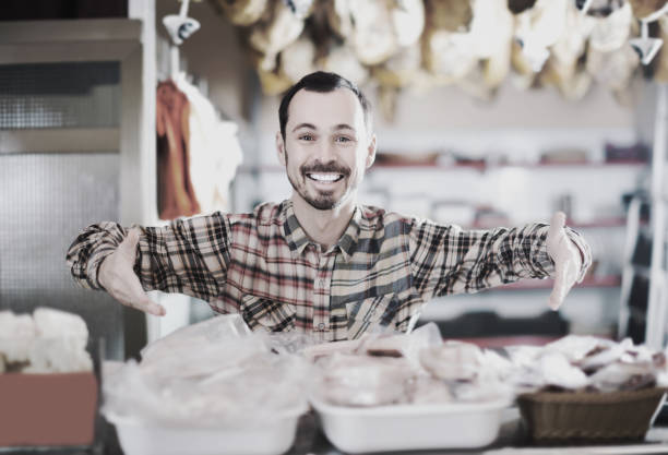 Smiling man butcher showing sorts of meat